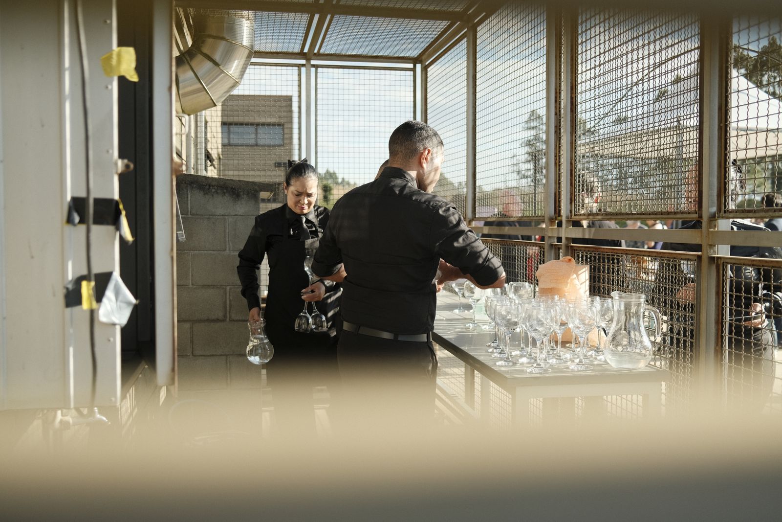 Event staff preparing glassware at a venue before guests arrive