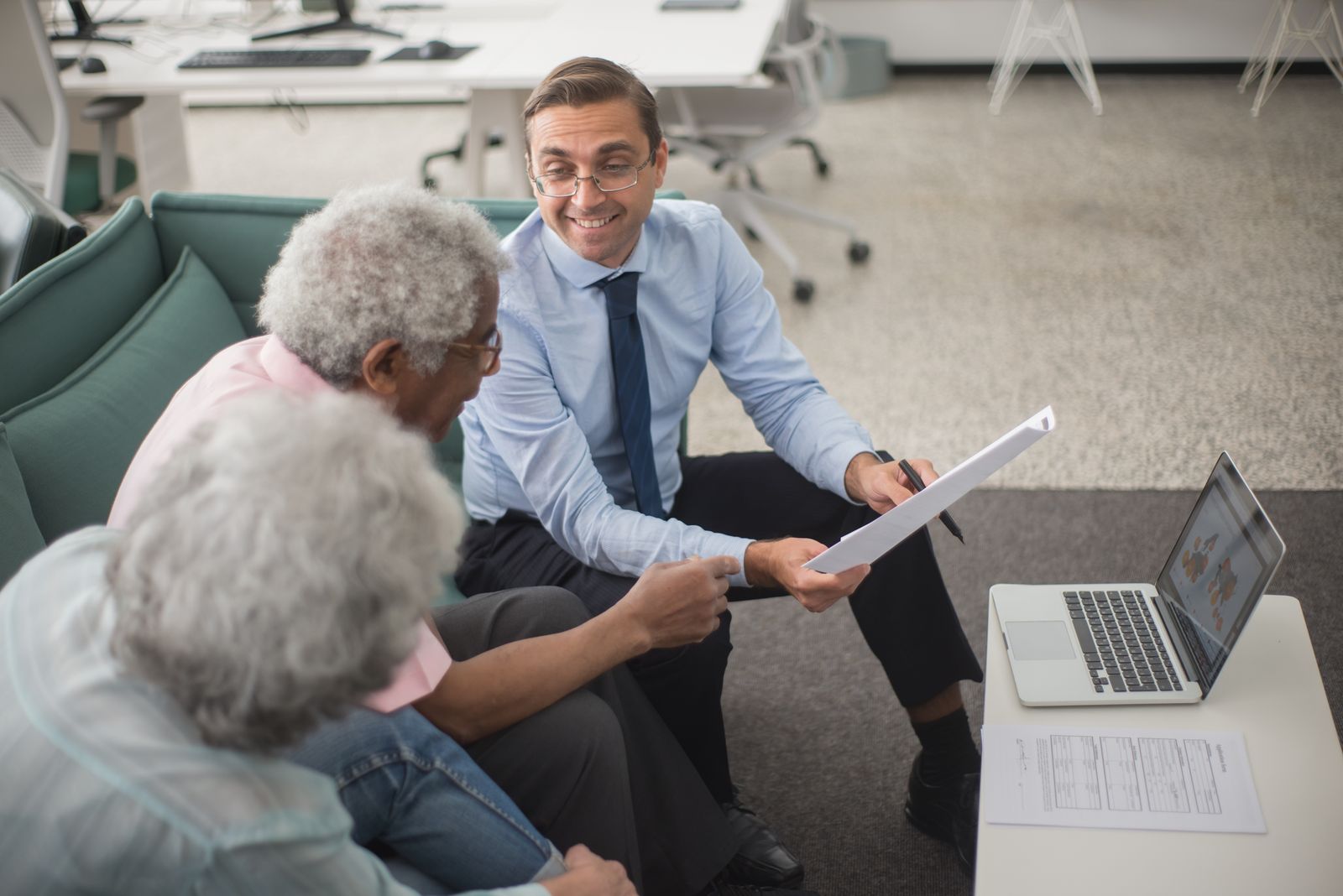 Financial advisor reviewing a plan with two clients in the office
