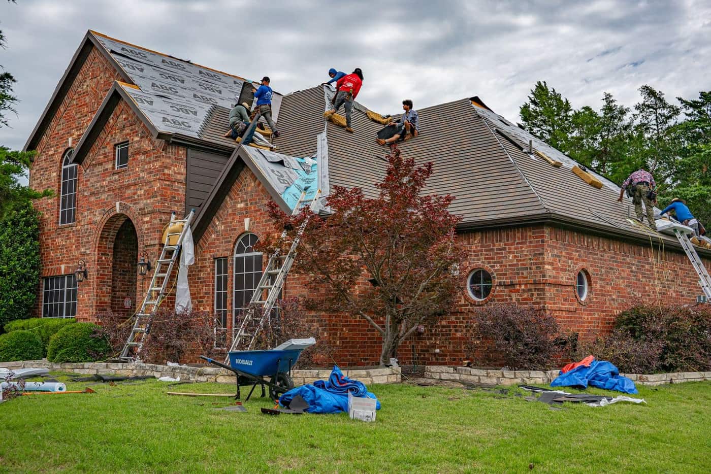 Roofing crew installing shingles on a residential roof